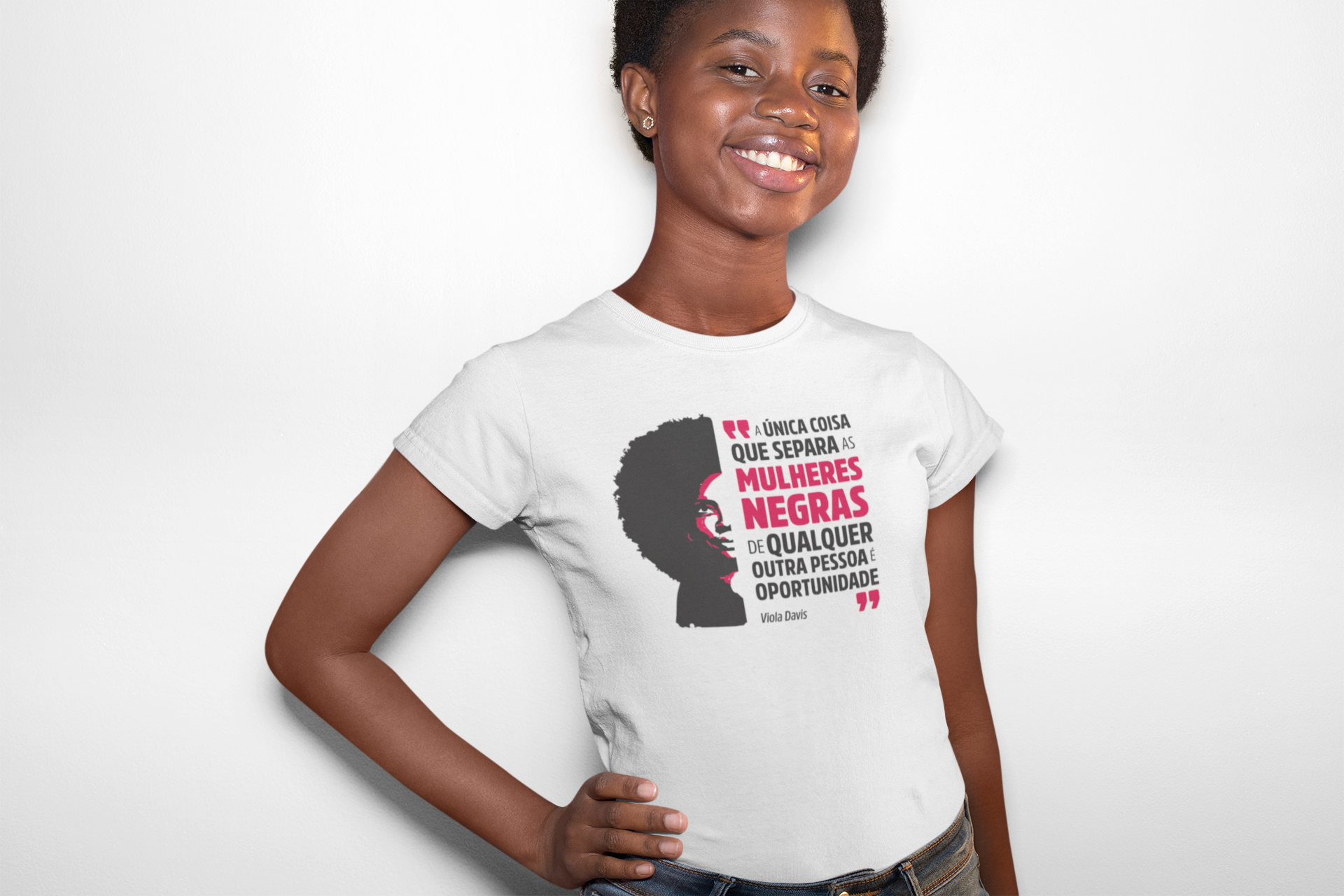 mulher negra vestindo a camiseta feminina branca com ilustração da Viola Davis e a frase "a única coisa que separa as mulheres negras de qualquer outra pessoa é oportunidade"